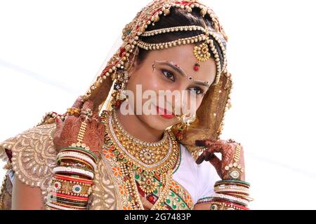 Portrait d'une femme hindoue asiatique indienne gujarati belle mariée élégante vêtue de vêtements de mariage traditionnels rouges hindous sari avec maquillage et bijoux Banque D'Images