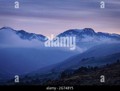 Lever du soleil vers le sommet du Tuc de Barlonguèra, le matin d'un printemps brumeux (Vallée de l'Aran, Catalogne, Pyrénées, Espagne) Banque D'Images