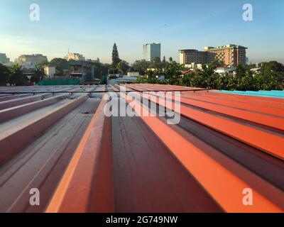 Couverture en tôle peinte en rouge et bleu contre une vue de la ville de Bangalore en arrière-plan Banque D'Images