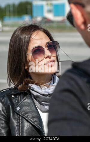 Belles personnes attirantes caucasiens ethnicité.Jeune couple sont debout avec des lunettes de soleil. Amoureux regardant les uns les autres. Deux modèles en cuir noir j Banque D'Images