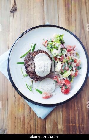 Hamburger frit avec salade fraîche. Arrière-plan en bois. Vue de dessus. Copier l'espace. Banque D'Images