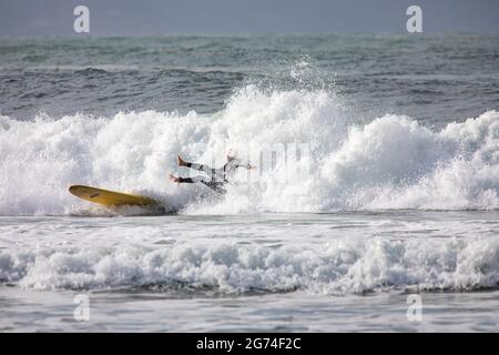 Un surfeur masculin de Palm Beach à Sydney dévie de sa planche de surf dans une grande vague le jour de l'hiver, Australie Banque D'Images