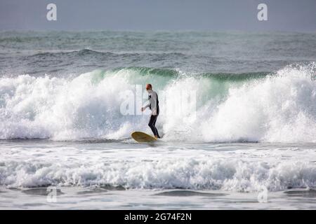 Un surfeur australien en combinaison fait du surf à Palm Beach à Sydney, Nouvelle-Galles du Sud, Australie Banque D'Images