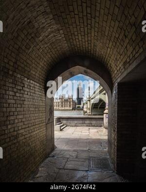 Le Parlement et le pont de Westminster encadrés par l'arche de la rive sud de la Tamise. Banque D'Images