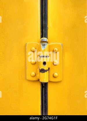 La charnière peinte d'une porte jaune Banque D'Images