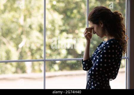 Malheureux femme latine désespérante se touchant la tête, se sentant mal de tête fort Banque D'Images