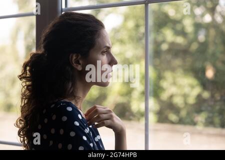 Femme millénaire frustrée et dépressive qui regarde la fenêtre Banque D'Images