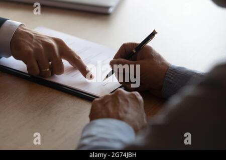 Les mains d'un avocat pointant sur le papier pour un homme d'affaires signant un contrat Banque D'Images