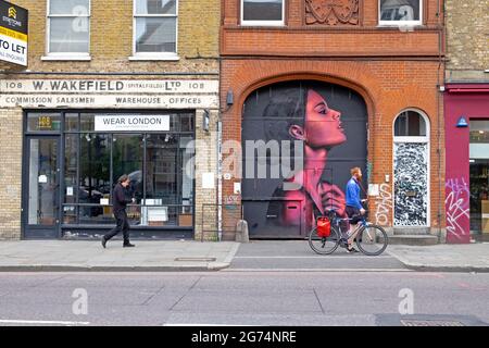 Personnes marchant devant la peinture murale art de la femme rose par l'artiste David Speed dans le quartier de Spitalfields Shoreditch East London UK KATHY DEWITT Banque D'Images