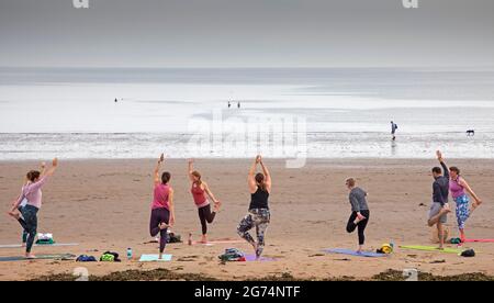 Portobello, Édimbourg, Écosse, météo britannique. 11 juillet 2021. Dreich Weekend pour terminer une semaine de temps rêveuse avec un haar constant et seulement quelques aperçus occasionnels de soleil sur la côte est écossaise. Température de 17 degrés centigrade pour ceux qui font de l'exercice au bord de la mer à côté du Firth of Forth. Photo : Jen McGregor prend un cours de yoga sur la plage. Crédit : Arch White/Alamy Live News. Banque D'Images