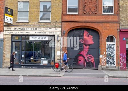 Personnes marchant devant la peinture murale art de la femme rose par l'artiste David Speed dans le quartier de Spitalfields Shoreditch East London UK KATHY DEWITT Banque D'Images