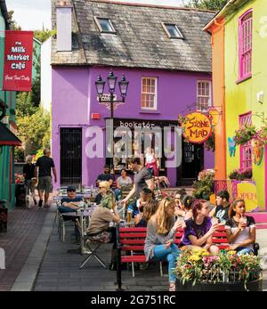 Kinsale, Comté de Cork, West Cork, République d'Irlande. Façades colorées. Scène typique de rue dans le centre-ville. Clients appréciant des boissons au pavillon Banque D'Images