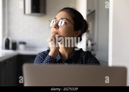 Une femme indienne attentionnés travaillant sur un ordinateur portable à la maison Banque D'Images