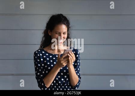 Joyeux utilisateur de téléphone portable excité lisant sur l'écran numérique et riant Banque D'Images