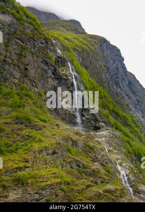 Petite cascade effrayante sur le côté de la montagne. Vue panoramique sur une chute d'eau tout en naviguant sur le fjord en Norvège. Banque D'Images