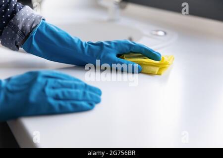 Femme au foyer, nettoyant, concierge portant des gants de protection bleus en caoutchouc Banque D'Images