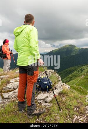 Des randonneurs mâles et femelles se tenant sur le pic Ushite dans la montagne de Troyan, réserve de biosphère de l'UNESCO, Bulgarie, dans le cadre du long chemin E3 Banque D'Images