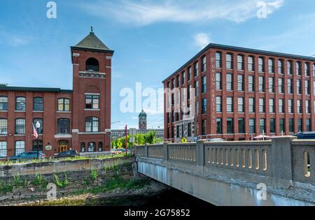 Vue sur la tour Bell et les bâtiments de Duck Mill le long de Union St. avec la tour de l'horloge Ayer au loin à Lawrence, Massachusetts. Banque D'Images