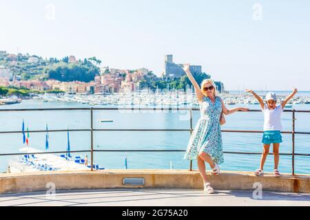 Mère et fille au lac de Garde avec montagnes, lac et ville sur le fond. Le lac de Garde est le plus grand lac d'Italie. Style de vie, vacances et Banque D'Images