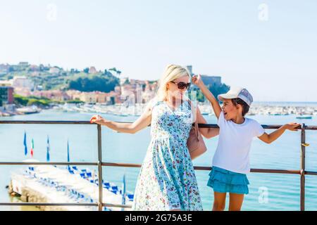 Mère et fille au lac de Garde avec montagnes, lac et ville sur le fond. Le lac de Garde est le plus grand lac d'Italie. Style de vie, vacances et Banque D'Images