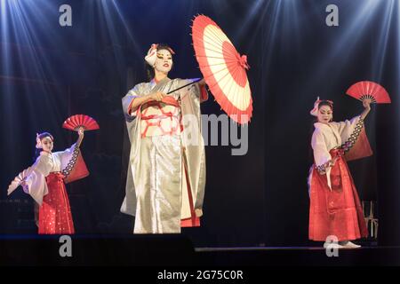 Les femmes japonaises dans les kimono traditionnels dansing avec parapluie et fans. Performances japonaises traditionnelles. Banque D'Images