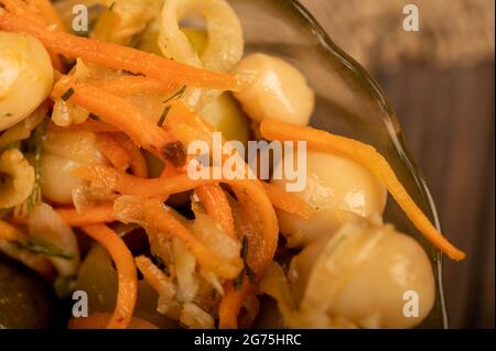 Champignons salés dans un plat en verre sur une table en bois. Gros plan mise au point sélective Banque D'Images