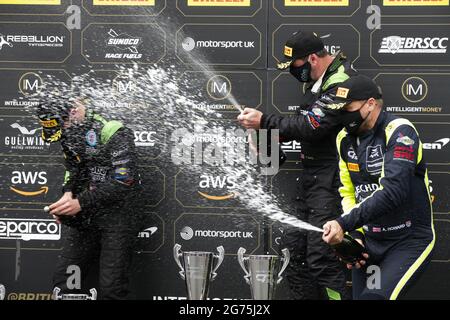 Castle Donington, Royaume-Uni. 11 juillet 2021. Le vainqueur de la course Sam Neary est arrosé de champagne par son coéquipier Richard Neary et Andrew Howrad lors du championnat Intelligent Money British GT à Donington Park, Leicestershire, Angleterre, le 11 juillet 2021. Credit: Jurek Biegus/Alamy Live News Banque D'Images