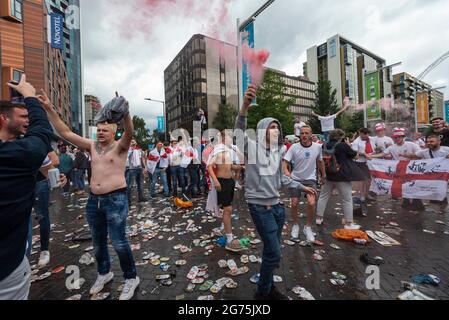 Londres, Royaume-Uni. 11 juillet 2021. Des canettes de bière jetées sur le sol tandis que les fans d'Angleterre illuminent les fusées à l'extérieur du stade Wembley, avant la finale de l'Euro 2020 entre l'Italie et l'Angleterre. C'est la première finale importante dans laquelle l'Angleterre aura joué depuis qu'elle aura remporté la coupe du monde en 1966 et l'Italie reste inbattue lors de leurs 33 derniers matches. Credit: Stephen Chung / Alamy Live News Banque D'Images