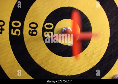 Flèche rouge de la fléchettes heurtant au centre de la cible du plan de travail avec un arrière-sol agréable. Concept de réussite commerciale illustré avec Dart et dartboard. Objectif marketing Banque D'Images