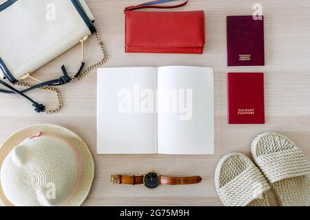 Composition d'arrière-plan de pose plate avec un chapeau d'été, un sac à main et un sac à main, une horloge, des sandales, des passeports et un livre ouvert Banque D'Images