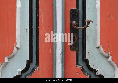 Détail d'une ancienne porte avant baroque peinte en rouge et gris Banque D'Images