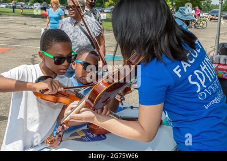 Detroit, Michigan - les garçons jouent le violon au stand Sphinx Overture lors d'un festival communautaire d'arts et de musique. L'organisation Sphinx a été fondée à un Banque D'Images