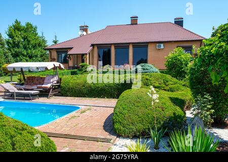 Villa de style européen avec piscine et jardin avec des buissons joliment taillés Banque D'Images