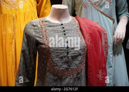 Femme indienne dernière robe de mode accrochée sur des cintres, en exposition dans un magasin de détail, dans le marché. Mariage indien de mariage pakistanais robes Lehenga sharara. - M Banque D'Images