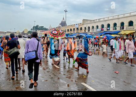 Photos des rues de la ville de Puri baignées de pluie le jour de Rath Yatra. Sri Mandir est visible au milieu des nuages de pluie en arrière-plan. Banque D'Images