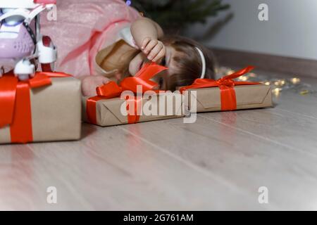 joyeuse petite fille se trouve par l'arbre de noël avec des cadeaux de noël, place pour le texte Banque D'Images