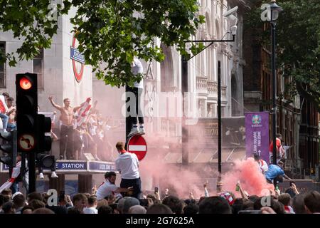 Heures avant que l'équipe de football d'Angleterre ne joue un jeu historique contre l'Italie la première fois depuis 1966 que l'équipe nationale anglaise joue dans une finale internationale de football des hommes, des milliers de supporters principalement jeunes se rassemblent sans couvre-visage ni distances sociales devant la station de métro Leicester Square, Le 11 juillet 2021, à Londres, en Angleterre. Banque D'Images