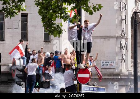 Heures avant que l'équipe de football d'Angleterre ne joue un jeu historique contre l'Italie la première fois depuis 1966 que l'équipe nationale anglaise joue dans une finale internationale de football des hommes, des milliers de supporters principalement jeunes se rassemblent sans couvre-visage ni distances sociales devant la station de métro Leicester Square, Le 11 juillet 2021, à Londres, en Angleterre. Banque D'Images