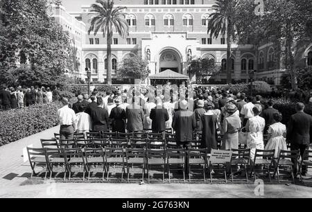 1964, les membres historiques, les parents et la famille se tenant à l'extérieur pour la cérémonie de remise des diplômes universitaires officiels, où les étudiants reçoivent leur certificat, Université de Californie du Sud (USC) Californie, États-Unis. Banque D'Images