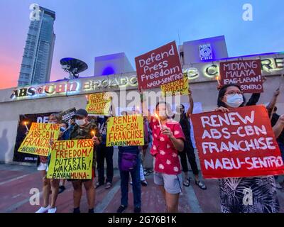 Des journalistes philippins, des activistes de la liberté de la presse, des partisans et des employés de l'ABS-CBN, le plus grand réseau de diffusion du pays, portent des signes pour protester contre le premier anniversaire du rejet d'une nouvelle franchise pour le réseau de radiodiffusion devant son siège à Quezon City, dans la région métropolitaine de Manille. Le 10 juillet 2021, le Congrès philippin a voté le rejet d'une nouvelle franchise pour le réseau multimédia ABS-CBN, après l'expiration de sa franchise de 25 ans. Philippines. Banque D'Images