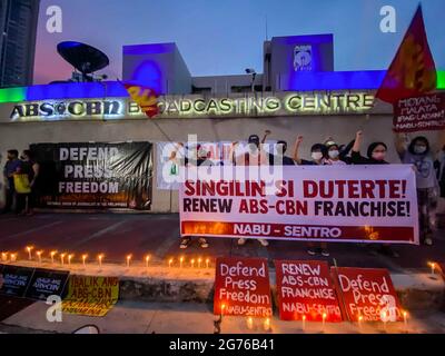 Des journalistes philippins, des activistes de la liberté de la presse, des partisans et des employés de l'ABS-CBN, le plus grand réseau de diffusion du pays, portent des signes pour protester contre le premier anniversaire du rejet d'une nouvelle franchise pour le réseau de radiodiffusion devant son siège à Quezon City, dans la région métropolitaine de Manille. Le 10 juillet 2021, le Congrès philippin a voté le rejet d'une nouvelle franchise pour le réseau multimédia ABS-CBN, après l'expiration de sa franchise de 25 ans. Philippines. Banque D'Images