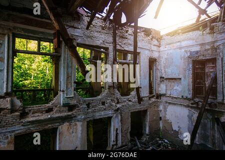 Intérieur en ruines d'un manoir surcultivé par des plantes. Nature et architecture abandonnée, concept post-apocalyptique vert. Banque D'Images