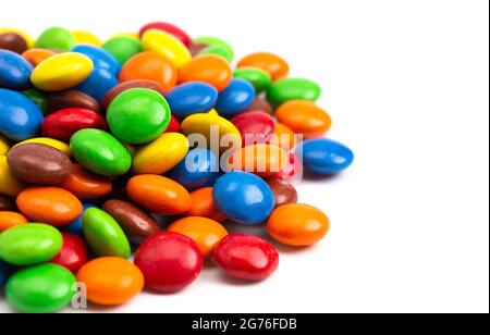 Pile de boutons de chocolat enrobés de Candy de couleur arc-en-ciel isolés sur un fond blanc Banque D'Images