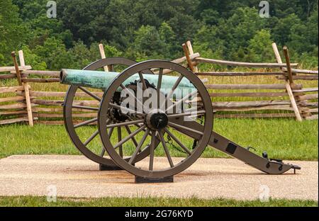 Gettysburg, PA, Etats-Unis - 14 juin 2008 : monuments du champ de bataille. Gros plan du canon dont le cuivre est devenu vert, sur des roues à feuillage vert et marron Banque D'Images