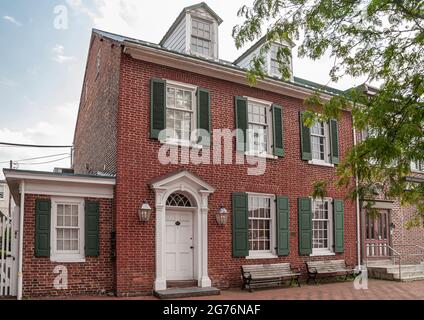 Gettysburg, PA, Etats-Unis - 14 juin 2008 : maison en briques rouges datant du siècle bien entretenu avec fenêtres et portes encadrées blanches et volets extérieurs verts. Bleu Banque D'Images