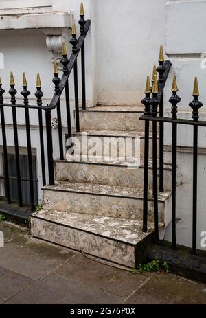 Série élégante de marches en pierre et de rambardes en fer forgé menant à la porte d'entrée de la maison à Kensington, Londres Banque D'Images