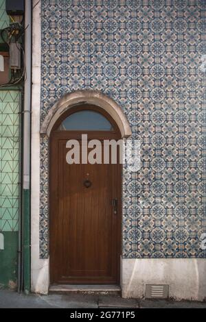 La porte du bâtiment traditionnel portugais. Vieux mur de tuiles sur la rue peint en étain vitrifié, azulejos. Banque D'Images