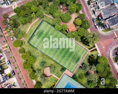 Un tir de drone de terrain de mini-football vide et un terrain de ténis entouré d'un parc et d'arbres dans une communauté fermée à l'extérieur de Guayaquil City, en Équateur. Banque D'Images
