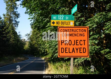 Carnation, WA, USA - 11 juillet 2021; un panneau orange et noir sur la route informe que le projet de construction de la route est retardé Banque D'Images