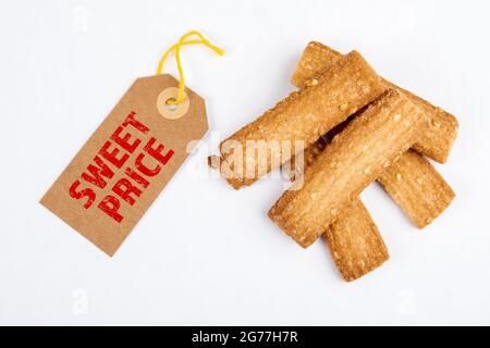 Prix doux. Concept de vente et de marketing. Étiquette de prix en carton et biscuits sur fond blanc. Banque D'Images